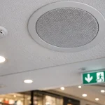 Głośnik sufitowy oraz elementy systemu DSO i czujka pożarowa w galerii handlowej